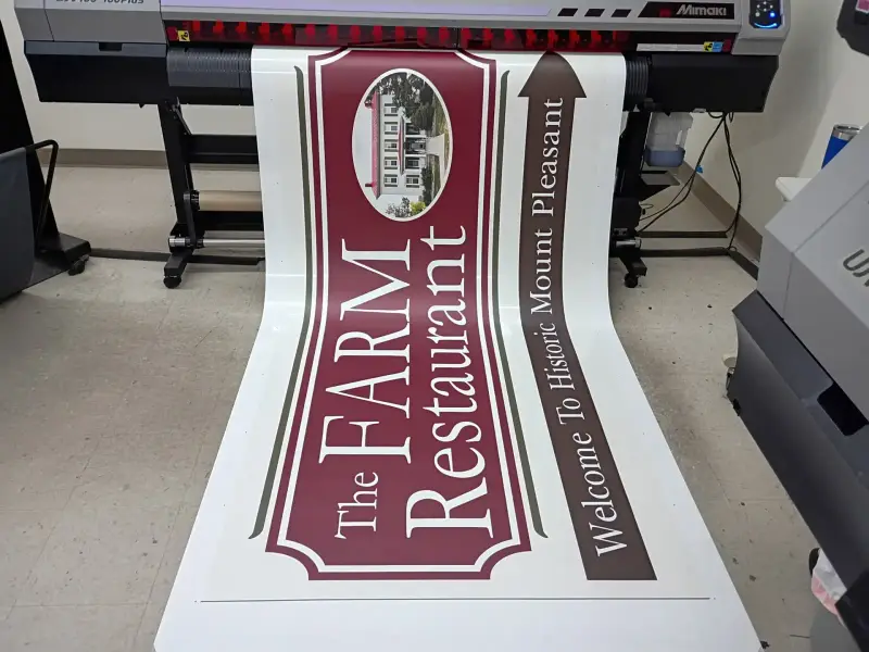Printed banner for The Farm Restaurant coming off a wide-format printer at Signs Limited