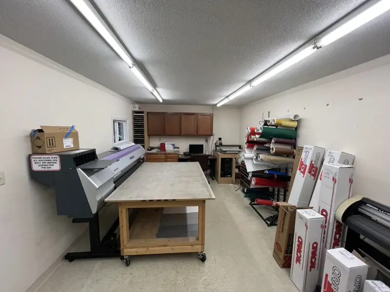 Design and production room at Signs Limited with printers and vinyl stock